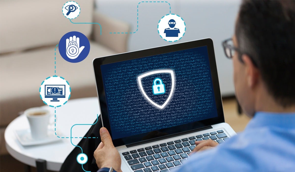 Homem segurando notebook com firewall ativo
